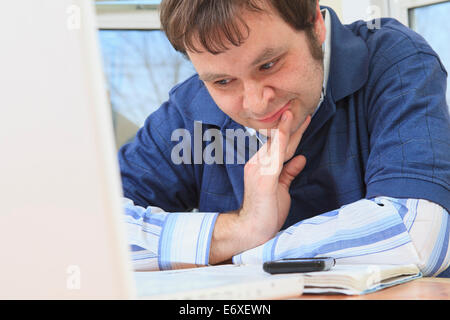 La tecnologia e l'ingegnere programmatore con Aspergers lavorando sul suo computer di casa Foto Stock