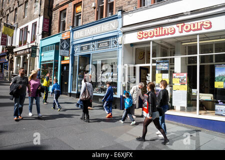 Acquirenti e turisti a piedi negozi passato sul Royal Mile di Edimburgo Foto Stock