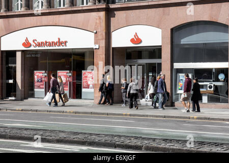 Gli amanti dello shopping a piedi passato banca Santander su Princes Street, Edinburgh Foto Stock