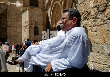 Persone riposo dopo la processione nel cortile della chiesa del Santo Sepolcro il Venerdì Santo nella Città Vecchia di Gerusalemme, Israele Foto Stock