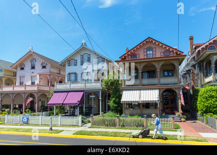 Stati Uniti d'America,New Jersey,Cape May, case vittoriane e persona la falciatura di prato anteriore. Foto Stock