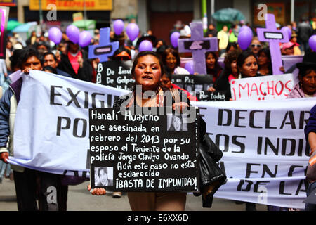 La Paz, Bolivia, 1 settembre 2014. Un attivista per i diritti delle donne porta un cartello che ricorda Hanali Huaycho durante una marcia per protestare contro la violenza contro le donne. La marcia è stata anche respinta le recenti dichiarazioni rilasciate da diversi candidati durante l'attuale campagna elettorale che sembrano minimizzare il problema e discriminare le donne. Secondo un rapporto DELL'OMS nel gennaio 2013, la Bolivia è il paese con il più alto tasso di violenza contro le donne in America Latina, dal 2006 si sono verificati 453 casi di femminicidio durante l'attuale governo. Crediti: James Brunker / Alamy Live News Foto Stock