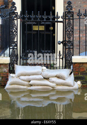 Sacchi di sabbia impilati nella parte anteriore della casa in York allagato street. Foto Stock