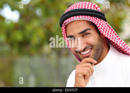 Ritratto di un bel saudita Arab Emirates uomo con un sorriso bianco e uno sfondo verde Foto Stock