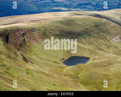 Guardando verso il basso sulla piccola cirque lago di Llyn Cym Llwch sotto la scarpata sul lato nord del mais Du Foto Stock
