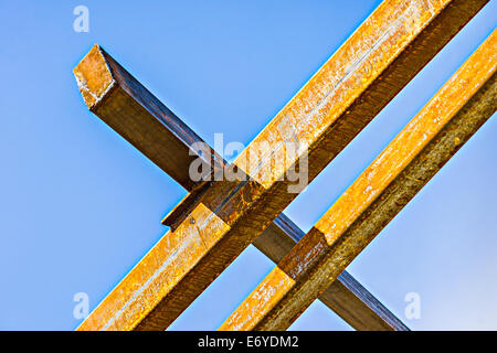 Rusty travi metalliche attraverso il cielo blu chiaro Foto Stock