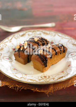 Mini dolci di mandorla con cioccolato fuso topping Foto Stock