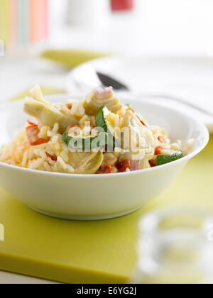 Risotto con carciofi, zucchine e pomodori secchi Foto Stock