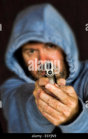 Ladro o pista gli stati in possesso di una pistola in una posizione minacciosa Foto Stock