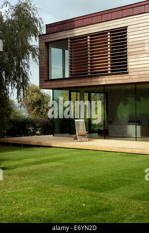 Casa modernista con sedia sulla terrazza in alberi- Ubly, Somerset, Regno Unito Foto Stock