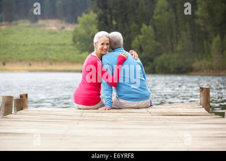 Senior romantica giovane seduto su di un molo Foto Stock