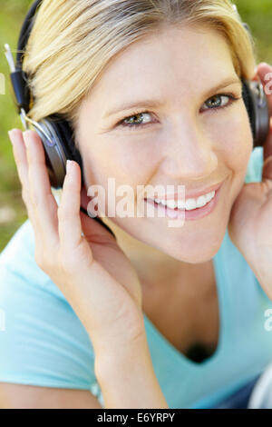 Donna che indossa le cuffie all'aperto Foto Stock