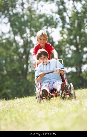 I ragazzi giocare con go-kart Foto Stock