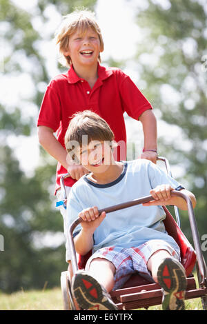 I ragazzi giocare con go-kart Foto Stock