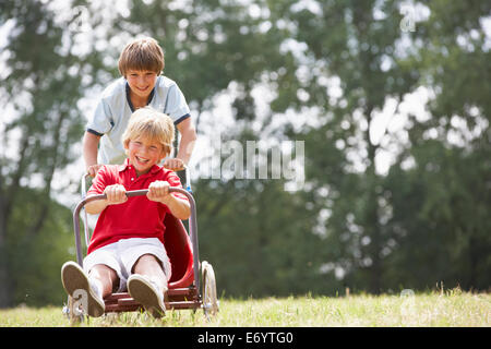 I ragazzi giocare con go-kart Foto Stock