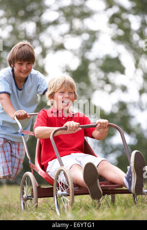 I ragazzi giocare con go-kart Foto Stock