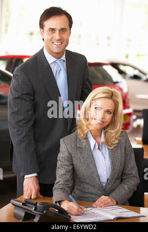 Le persone che lavorano in showroom per auto Foto Stock
