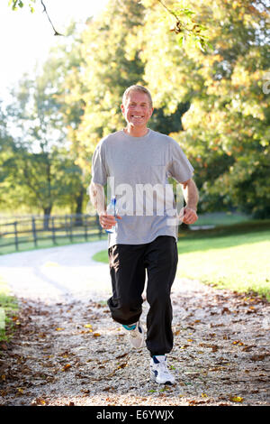 Senior uomo correre in posizione di parcheggio Foto Stock