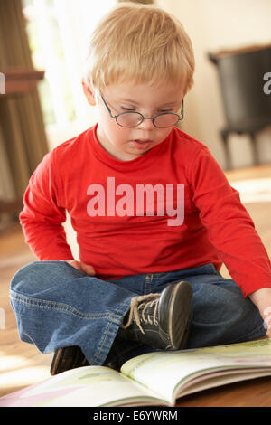 4 anno vecchio ragazzo con la sindrome di Down la lettura Foto Stock