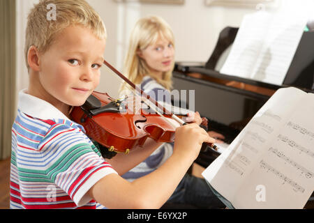 Un ragazzo e una ragazza suona il violino e pianoforte a casa Foto Stock