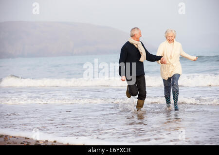 Coppia senior lungo la Spiaggia Invernale Foto Stock