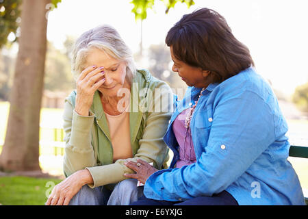 Donna consolante infelice amico Senior all'aperto Foto Stock