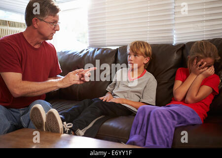 Padre essendo fisicamente offensivo verso i bambini a casa Foto Stock