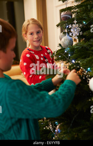 Bambini decorare albero di Natale a casa Foto Stock