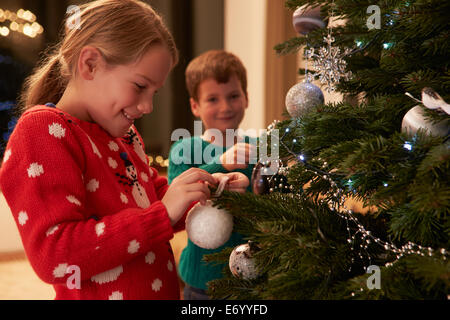 Bambini decorare albero di Natale a casa Foto Stock