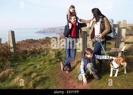 Famiglia con il cane a camminare lungo il sentiero costiero Foto Stock