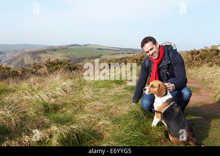 L'uomo con il cane a camminare lungo il sentiero costiero Foto Stock