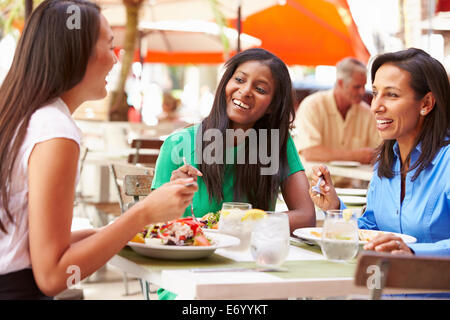 Il gruppo di amici di sesso femminile godendo il pranzo in un ristorante esterno Foto Stock