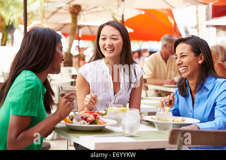 Il gruppo di amici di sesso femminile godendo il pranzo in un ristorante esterno Foto Stock