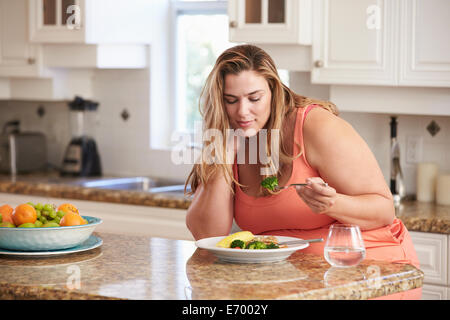 Donna sovrappeso mangiare sano pasto in cucina