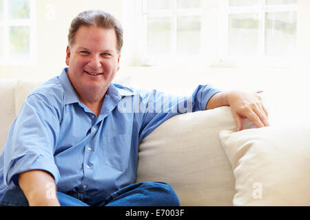 Ritratto di sovrappeso uomo seduto sul divano Foto Stock