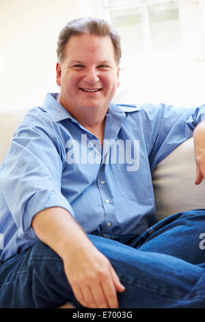 Ritratto di sovrappeso uomo seduto sul divano Foto Stock