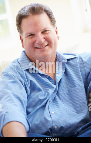 Ritratto di sovrappeso uomo seduto sul divano Foto Stock