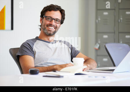 Ritratto di casualmente vestito uomo al lavoro in studio di design Foto Stock