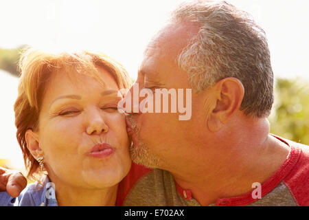 Affettuosa coppia Senior baciare in giardino Foto Stock