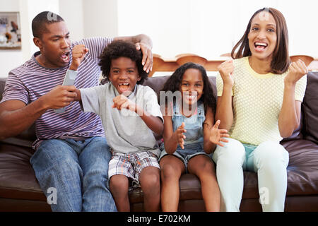 Famiglia seduti sul divano guardando la TV insieme Foto Stock