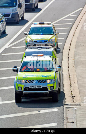 Highways Agency ufficiali del traffico auto & NHS paramedico ambulanza tramite autostrada spalla duro per raggiungere la scena di un incidente Foto Stock