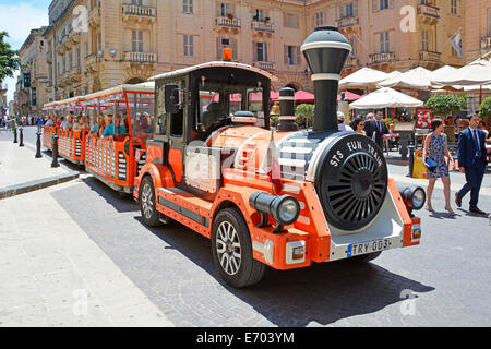 Scena stradale divertente treno stradale e carrozze parcheggiate aspettando più persone per il tour turistico nella storica Valletta parcheggiata nel centro della città Malta EU Foto Stock