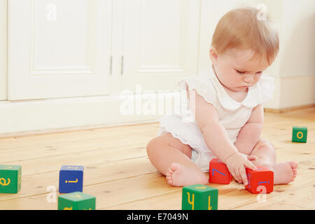 Bambina gioca sul pavimento con la costruzione di blocchi Foto Stock