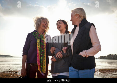 Femmina i membri di famiglia in chat sulla spiaggia Foto Stock