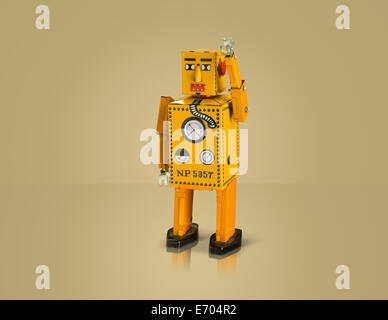 Studio shot di robot giallo con il braccio sollevato Foto Stock