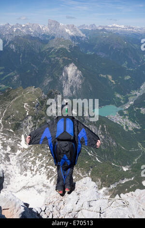 Metà uomo adulto BASE jumping dal bordo di montagna, Alleghe, Dolomiti, Italia Foto Stock