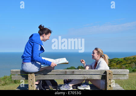 Due giovani donne seduta sul banco di lavoro con mappa Foto Stock