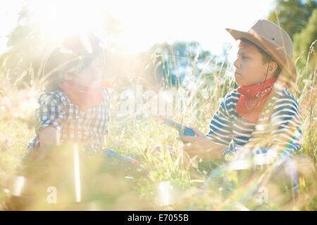 Due giovani ragazzi vestito da cowboy, tenendo pistole giocattolo Foto Stock