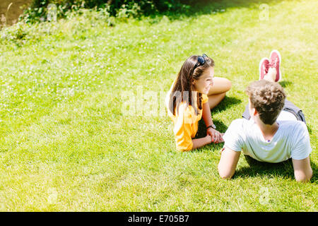 Giovane seduto sull'erba nel parco Foto Stock