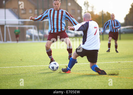 I giocatori di calcio in lotta per la sfera Foto Stock